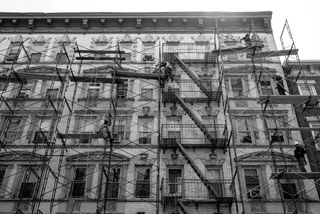 Construction workers working on scaffolding attached to a building