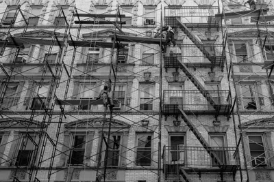 Construction workers working on scaffolding attached to a building