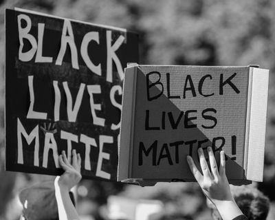 Hands holding up Black Lives Matter protest signs