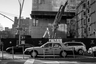 Cars passing by a building construction site near the entrance to the Holland Tunnel