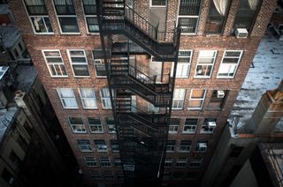 View looking down at side of apartment building with fire escape