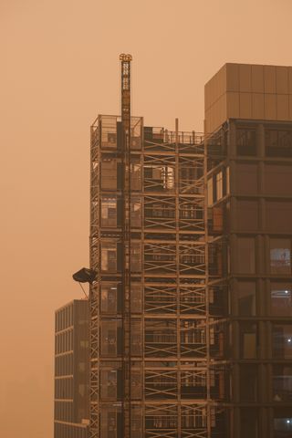 Upper part of a building in Manhattan’s Soho neighborhood under an orange-tinted sky